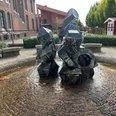Zwergenbrunnen Moderne Skulptur aus geometrischen Formen mit Wasserspiel, platziert auf einem gepflasterten Platz.Modern sculpture of geometric shapes with water feature, placed on a paved square.Moderne skulptur af geometriske former med vandfunktion, placeret på en brolagt plads.Moderne sculptuur van geometrische vormen met waterpartij, geplaatst op een betegeld plein.
