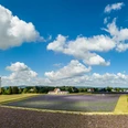 Naturduft Manufaktur TAOASIS Weite Lavendelfelder erstrecken sich unter einem klaren, blauen Himmel mit weißen Wolken.