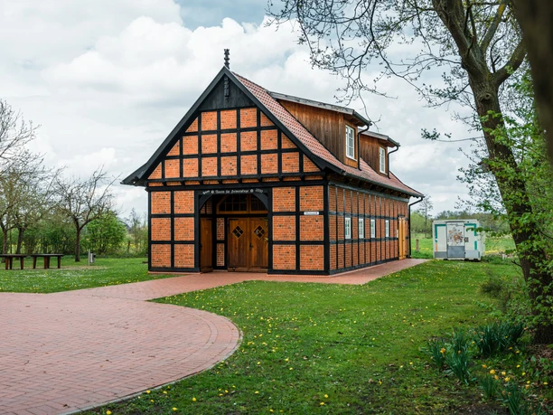 Hochzeitsmühle Tonnenheide Fachwerkhochzeitsmühle Tonnenheide mit grüner Wiese und blühenden Narzissen im Vordergrund.