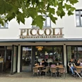 Herford-Piccoli-Aussen-Pro Herford GmbH.jpg Außenansicht des Restaurants Piccoli mit Gästen, die an Tischen vor großen Fenstern sitzen.