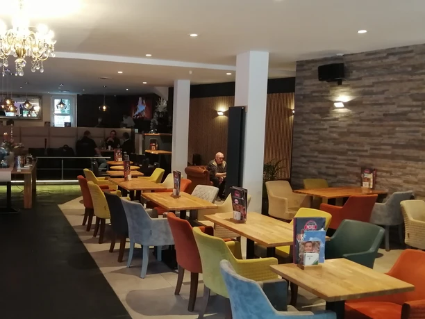 Ein modernes Café mit vielseitigen Sitzmöglichkeiten und einer einladenden Atmosphäre.