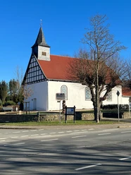 Die Heilig-Kreuz-Kapelle Haldem hat ein rotes Ziegeldach und Fachwerkelemente an den Giebelseiten.
