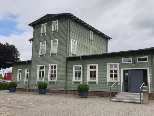 Bahnhof Rahden Historischer Bahnhof Rahden mit grüner Holzfassade und symmetrischen weißen Fenstern.