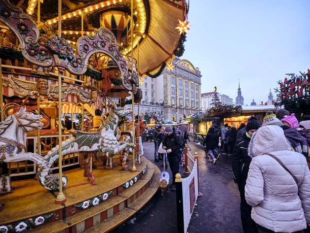 Historisches Karussell am Dresdner Striezelmarkt.jpg Historisches Karussell auf dem Dresdner Striezelmarkt mit leuchtenden Lichtern und dekorativen Pferden.