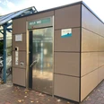 Bahnhof Ratzeburg_WC1_Petra Roemer_20241022.jpg Am Bahnhof steht ein öffentliches Toilettenhäuschen mit silberner Tür, daneben überdachte Fahrradstellplätze