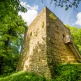 Preußisch-Oldendorf-Burg Limberg Burg Limberg: Ein mittelalterlicher Turm aus Stein, umgeben von grüner Vegetation und Bäumen.