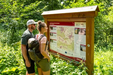 Preußisch-Oldendorf Wiehengebirge Zwei Wanderer lesen aufmerksam eine Informationstafel zu Wanderwegen im Wiehengebirge.