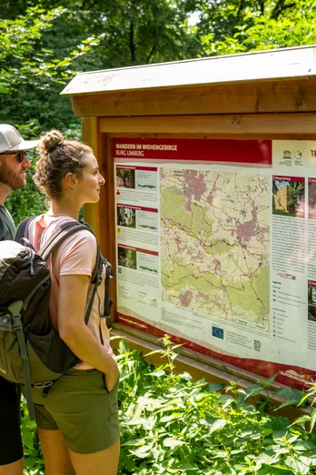 Preußisch-Oldendorf Wiehengebirge Zwei Wanderer lesen aufmerksam eine Informationstafel zu Wanderwegen im Wiehengebirge.