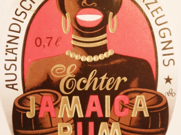 JamaicaRum Etikett mit farbenfroher Illustration einer Frau mit Schmuck und einem Fass. Text: "Echter Jamaica Rum".