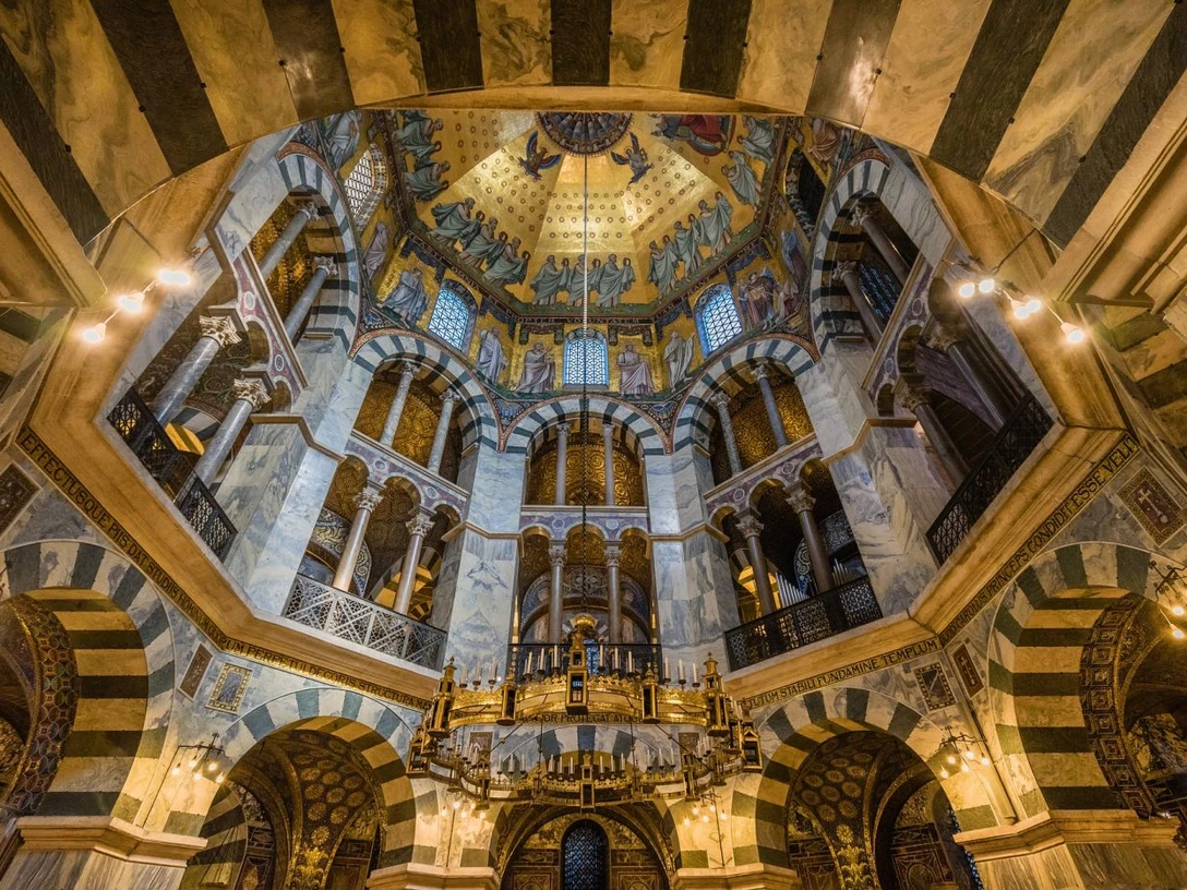 Der Aachener Dom Oktogon des Aachener Doms von innen mit Kronleuchter in der Mitte.