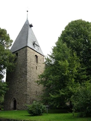Kirche in Extertal-Almena.jpg Steinernen Kirchturm mit spitzem Dach in grüner Umgebung, historische Architektur in Extertal-Almena.