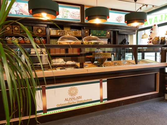 Al Halabi – Orientalische Süßigkeiten in Leipzig Zu sehen ist eine moderne Theke des Geschäft, die eine Auswahl an verschiedenen Süßigkeiten präsentiert
