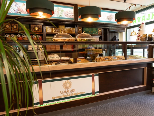 Al Halabi – Orientalische Süßigkeiten in Leipzig Zu sehen ist eine moderne Theke des Geschäft, die eine Auswahl an verschiedenen Süßigkeiten präsentiert