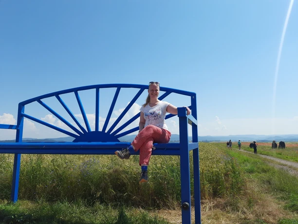 Grünstiefel Julia Friedrich auf der blauen Mitmachbank im Mohn