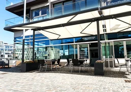 Hafenterrasse (Weitansicht) Terrasse mit Sitzgelegenheiten und SonnensegelTerrace with seating and awning