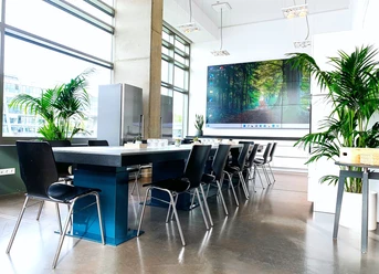 Konferenzbereich Conference area with block seating, plants and large screen