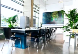 Konferenzbereich Konferenzbereich mit Blockbestuhlung, Pflanzen und großer LeinwandConference area with block seating, plants and large screen