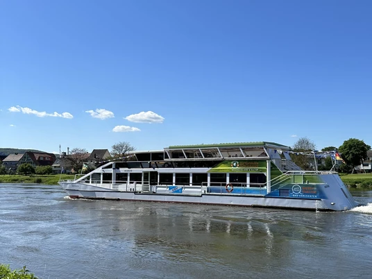 Weißes Weserschiff Hessen auf der Weser, im Hintergrund Uferbereich mit Häusern