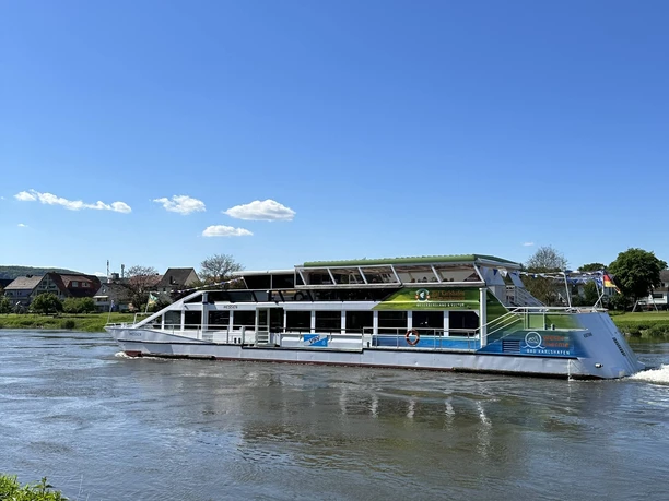 Weißes Weserschiff Hessen auf der Weser, im Hintergrund Uferbereich mit Häusern
