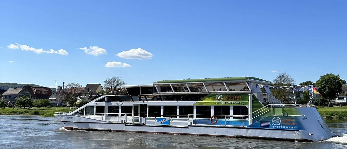 Weserschiff "Hessen" Weißes Weserschiff Hessen auf der Weser, im Hintergrund Uferbereich mit Häusern
