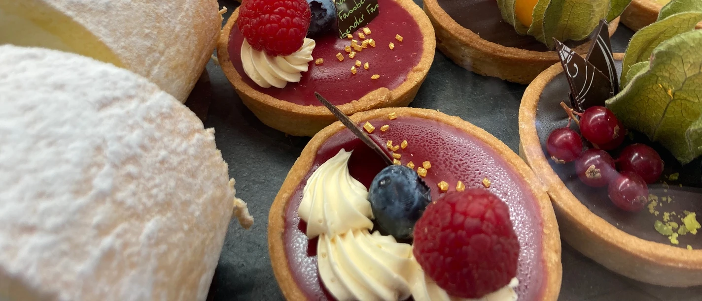 Süßes Köln Eine köstliche Auswahl bunter Törtchen und süßer Gebäcke, verziert mit frischen Beeren.