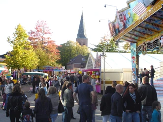 werlter-herbstmarkt-mit-kirche Bunte Marktstände, Fahrgeschäfte und viele Besucher vor der Kirche beim Werlter Herbstmarkt.