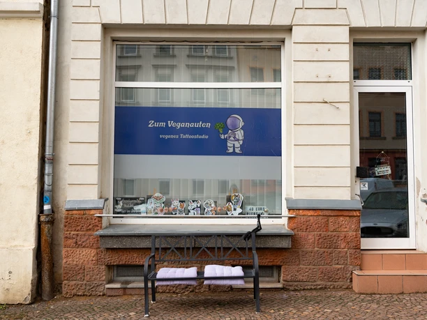 Zum Veganauten Tattoostudio Außenansicht Das Logo des Tattoostudios ist ein kleiner Astronaut, der einen Brokkoli hält