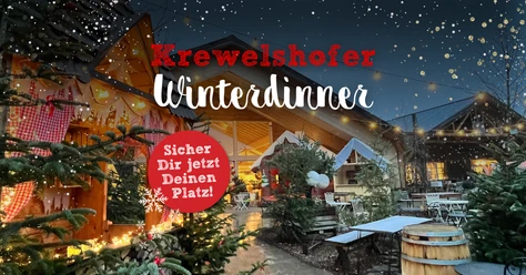 Winterdinner Beleuchteter Weihnachtsmarkt mit Tannenbäumen und dekorierten Holzhütten bei Nacht.