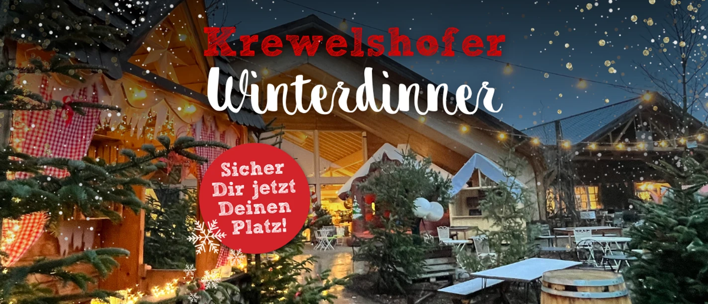 Winterdinner Beleuchteter Weihnachtsmarkt mit Tannenbäumen und dekorierten Holzhütten bei Nacht.