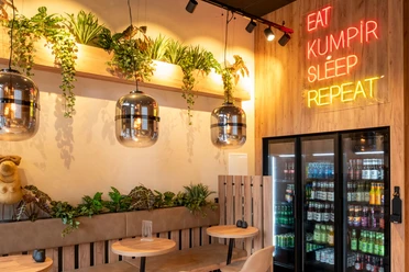 Restaurant Eat Kumpir Modern restaurant with wood-paneled walls and neon lighting.