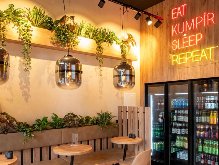 Restaurant Eat Kumpir Moderneingerichtetes Restaurant mit Holzvertäfelten Wänden und Neonbeleuchtung.Modern restaurant with wood-paneled walls and neon lighting.