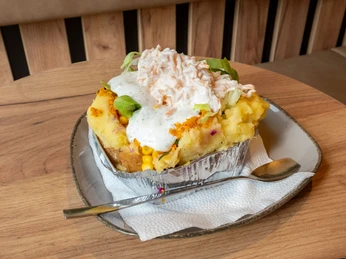 Restaurant Eat Kumpir Gefüllte Kartoffel mit Frühlingszwiebeln, Jogurt und Käse.Stuffed potato with spring onions, yogurt and cheese.