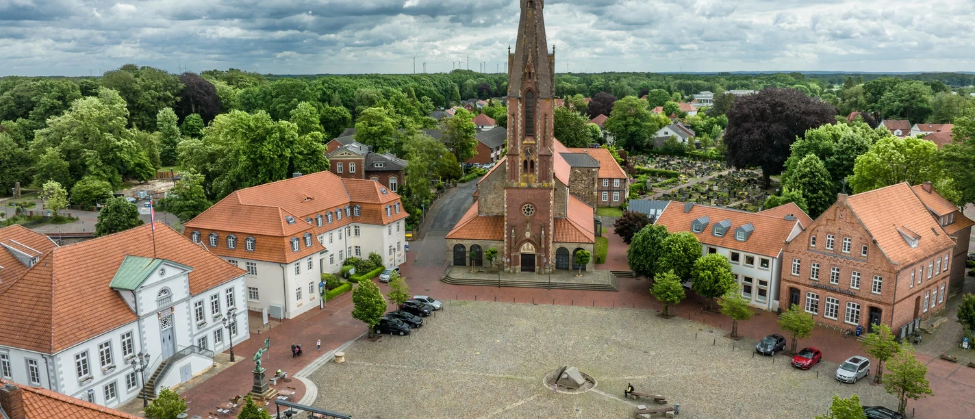 Aerial view of a historic market square with an impressive church in the center.