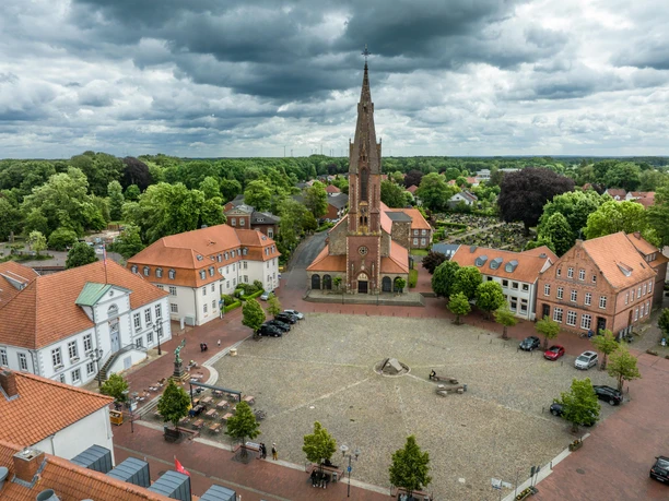 Marktplatz Quakenbrück Luchtfoto van een historisch marktplein met een indrukwekkende kerk in het midden.