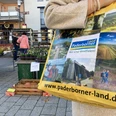 Büren Wochenmarkt Eine Einkaufstasche mit Paderborner Motiven wird auf einem belebten Wochenmarkt in Büren getragen.
