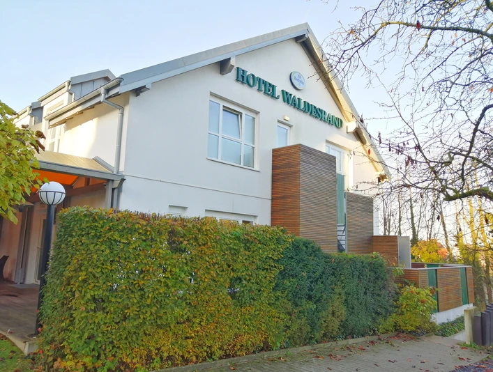 Hotel Waldesrand Herford_Aussenansicht_Pro Herford GmbH (3).jpeg Wohltuendes Hotel am Waldrand, umgeben von Grün, mit modernem Eingangsbereich und gepflegten Außenanlagen.