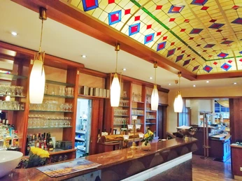 Hotel Waldesrand Herford_Buffet_Pro Herford GmbH (4).jpeg Hotelbar mit beleuchtetem Glasdach, ausgestattet mit Gläsern und Flaschen sowie einem stilvollen Tresen.