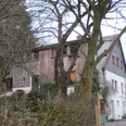 Bergheimat Oberbauerschaft Ein traditionelles Landhaus mit Holzelementen, umgeben von kahlen Bäumen an einem bewölkten Tag.