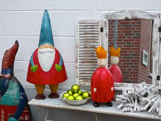 Adventsbasar Zu sehen sind ein paar weihnachtliche Dekofiguren und grüne Baumkugeln.