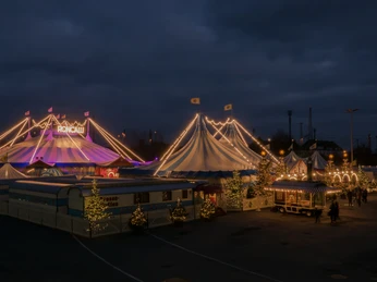 Roncalli-Zirkuszelt-c-schumburg-photography.jpg Ein beleuchtetes Zirkuszelt bei Nacht mit festlichen Lichtern und einer stimmungsvollen Atmosphäre.
