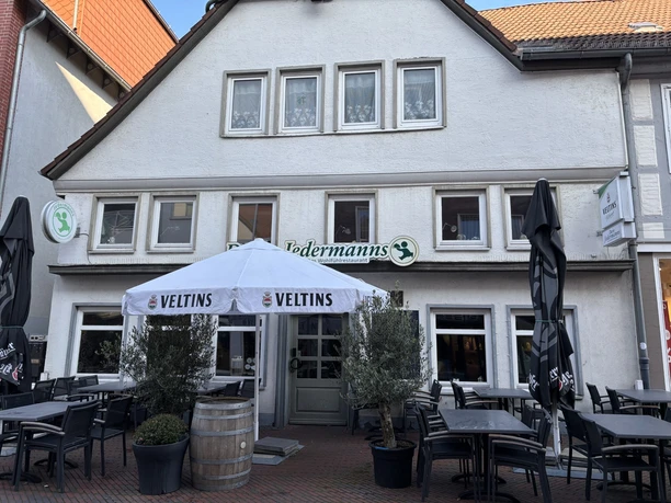 Jedermann_1.jpg Historisches Fachwerkhaus mit Außenterrasse, Tischen und Sonnenschirm des Restaurants "Jedermanns".
