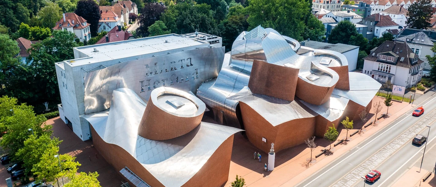 herford-marta-herford-teutoburger-wald-tourismus-h-tornow-003-cc-by-sa-jpg.jpg Marta Herford: Modernes Kunstmuseum mit beeindruckender Architektur, umgeben von grüner Kulisse.