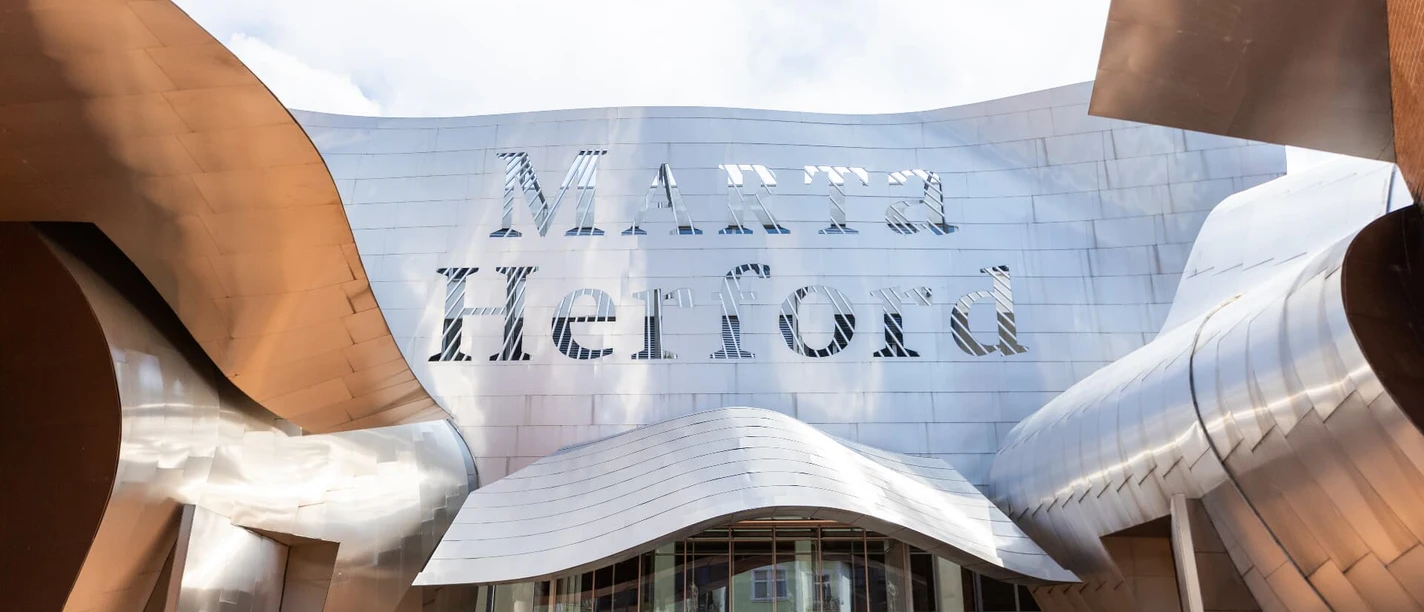 Futuristisches Museum Marta Herford mit geschwungener Metallfassade und gläsernem Eingangsbereich.