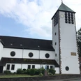 Katholische Wallfahrtskirche St. Marien Wallfahrtskirche St. Marien mit hohem Turm und Uhr, umgeben von Bäumen, nahe einer Straße gelegen.