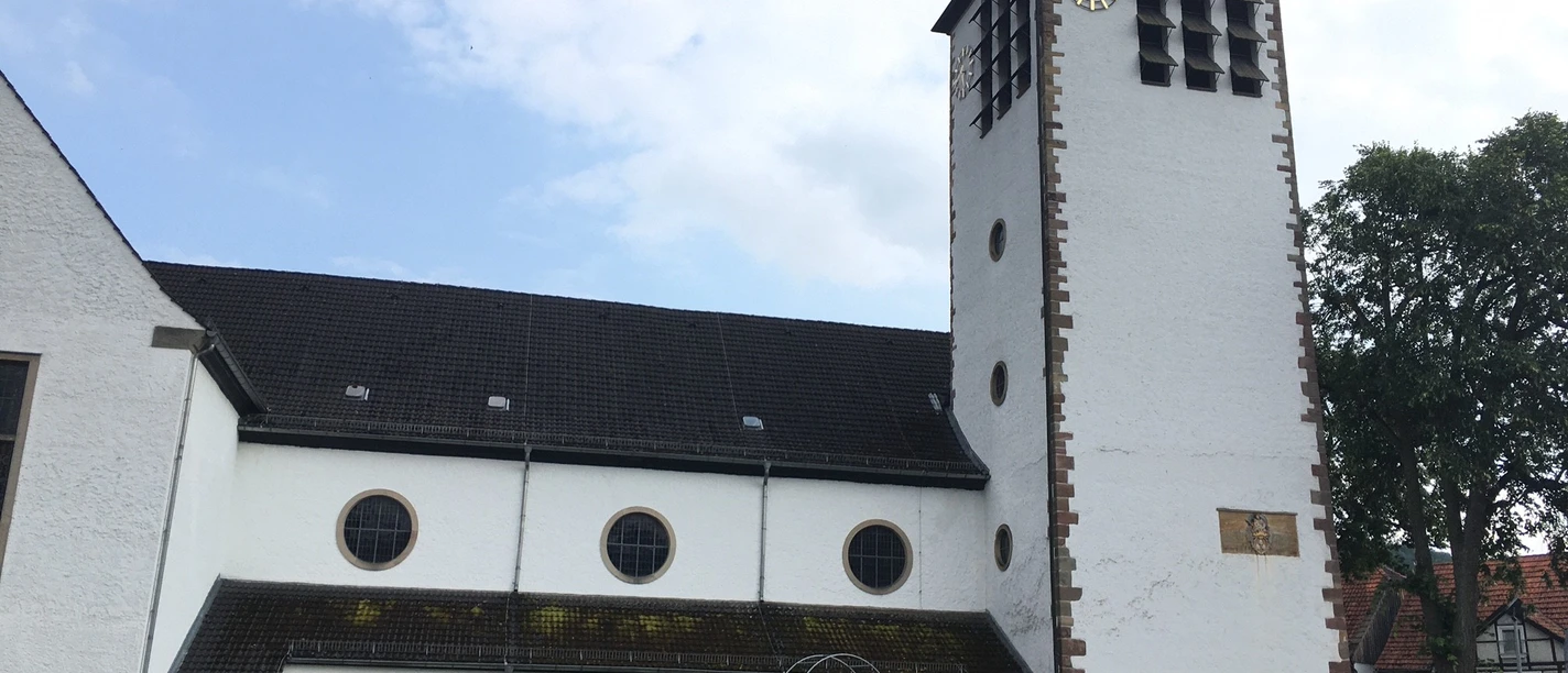Katholische Wallfahrtskirche St. Marien Wallfahrtskirche St. Marien mit hohem Turm und Uhr, umgeben von Bäumen, nahe einer Straße gelegen.