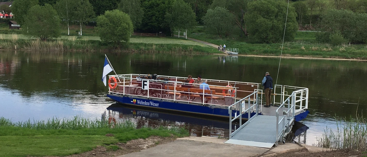 Personenfähre Wehrden am Flussufer der Weser, umgeben von grüner Landschaft..