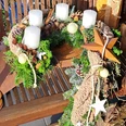 KiWiMedia_Webcode_23557569_Tina Böschen _ kreativwerk florales_2024-11-07.jpg Adventskranz mit weißen Kerzen, Tannenzweigen, Zapfen, Holzelementen und goldenen Sternen.