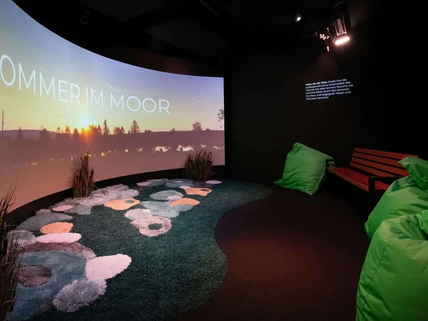 Moorerlebniswelt-Bad-Driburg-Kabinette Kinoraum in der Moorerlebniswelt mit Leinwand und Sitzecke.