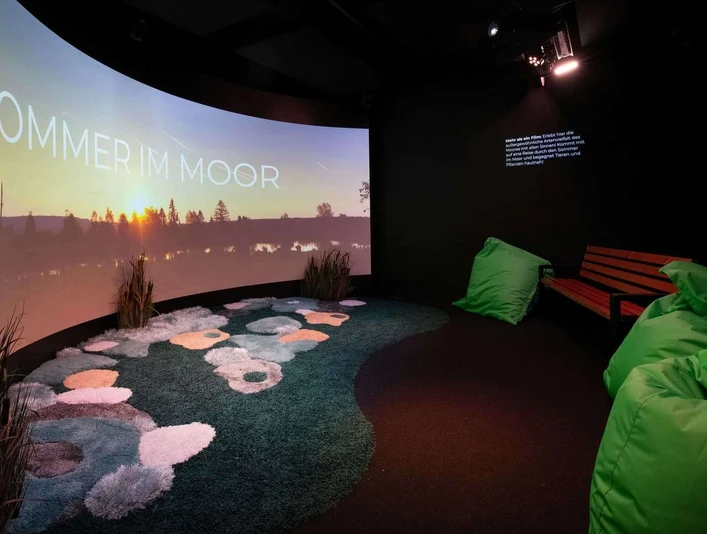 Moorerlebniswelt-Bad-Driburg-Kabinette_82.jpg Kinoraum in der Moorerlebniswelt mit Leinwand und Sitzecke.
