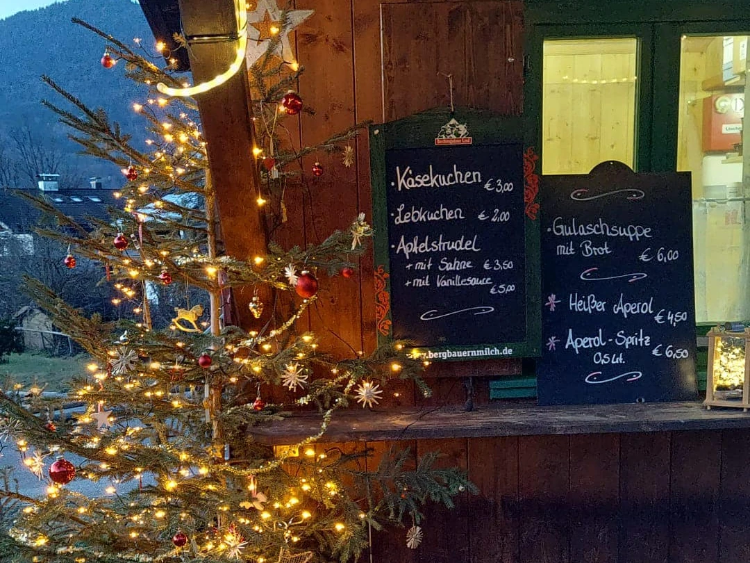 Steffi´s Hütte am Ried Farchant Geschmückter Tannenbaum vor uriger Hütte mit Preistafeln für Speisen und Getränke